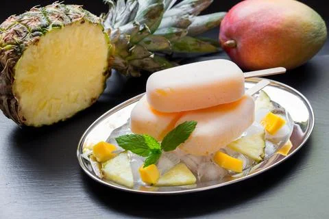 Mango pineapple icecream served on a silver plate with fresh pineapple and mango Stock Photos