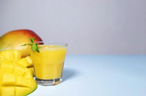 Mango Shake on Blue Background. Healthy Drinking Vitamin Smoothie with mint Stock Photos