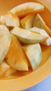 Mango slices in an orange bowl Stock Photos