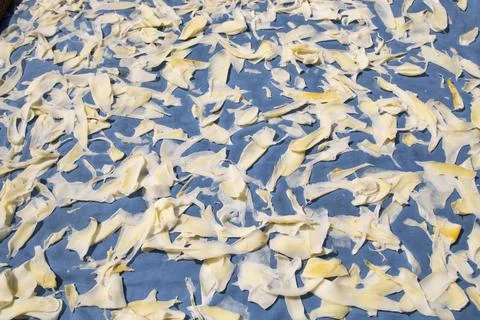 Mango slices under the sun for drying on a blue cloth. mango powder making fo Stock Photos