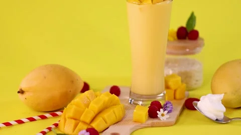 Mango Smoothie and Fresh Fruit on Vibrant Yellow Background Stock Footage 321046844