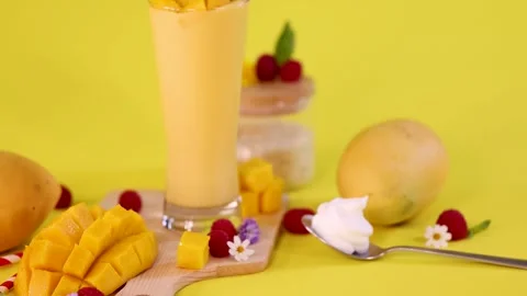 Mango Smoothie with Fresh Fruit and Whipped Cream on Yellow Stock Footage 321666421