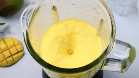 Mango smoothie or milkshake blended in blender with splashes Stock Footage 226126966