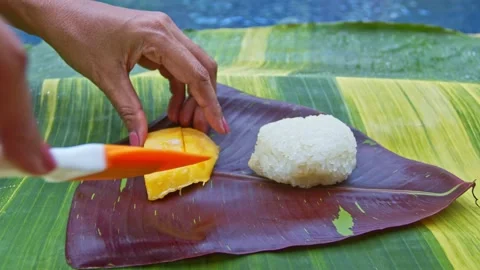 Mango sticky rice served on a spotted banana leaf by the pool. Stock Footage 158472867