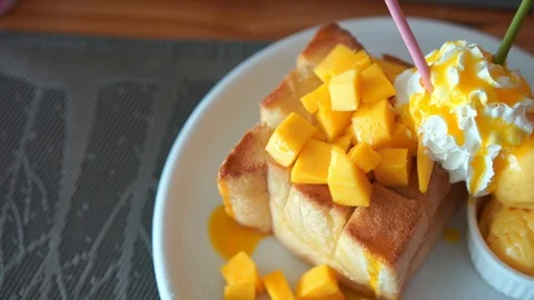 Mango toast bread with ice-cream and whip topping, top view panning footage Stock Footage 94137964