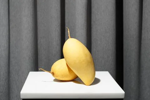 Mango tropical fruit in grey background. Minimalistic clean nature morte. Stock Photos
