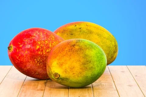 Mangoes 3d rendering with realistic texture on the wooden table Illustrazione stock