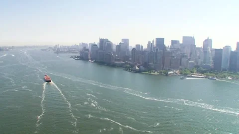 Manhattan skyline with a ferry passing through the waters in New York City Stock Footage 313709772