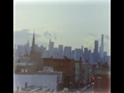 Manhattan skyline over Brooklyn rooftops. Dusk. 8mm film footage. Stock Footage 75331636