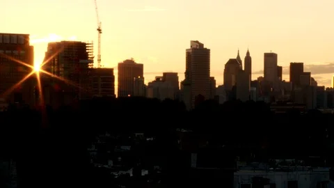 Manhattan skyline with sun setting between buildings. Vídeo Stock 106257843