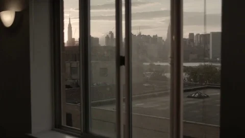 Manhattan skyline view through a window. Sunset. Camera panning. Vídeo Stock 75273007