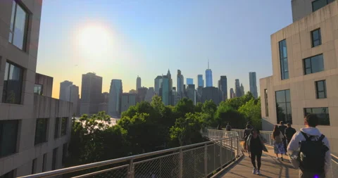 Manhattan skyscraper stands beyond Squibb Park Bridge in Brooklyn Bridge Park Stock Footage 243051231
