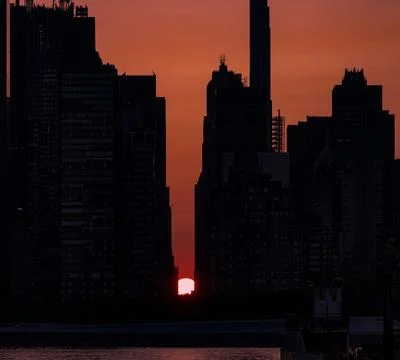 Manhattanhenge  summer sun setting between buildings Stock Photos