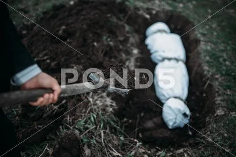 Maniac buries victim into a grave, crime horror Stock Photos