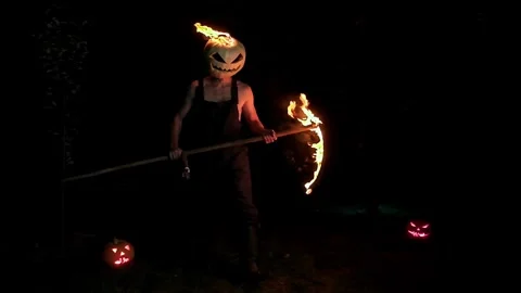 A maniac with a burning pumpkin instead of a head and a burning Stock Footage 251829701