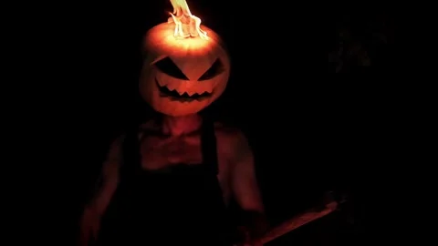 A maniac with a burning pumpkin instead of a head and a burning scythe Stock Footage 251829718