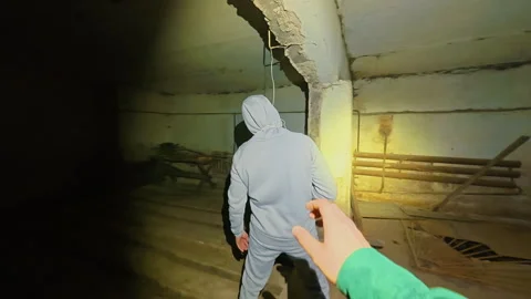 The maniac pretends to be hanged in the basement and attacks sharply. Stockbeeldmateriaal 331150128
