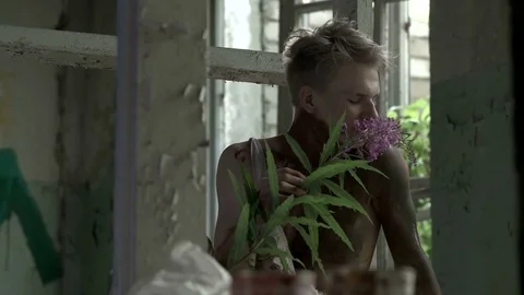 Maniac sniffs a flower and throws it on the floor Stock Footage 78203380