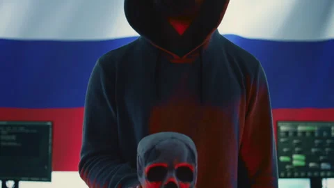 A maniacal russian hacker creating cyber threat alert by holding a skull Stock Footage 277657192