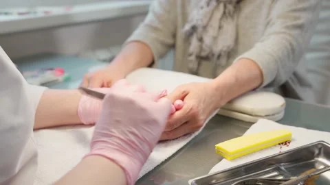 Manicure care procedure. Closeup view of beautician's hand filing nails of woman Stock-Footage 150607423
