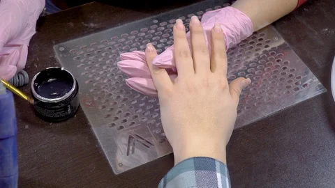 Manicure master applying gel base on the nails of the client in the beauty salon Video stock 103477173