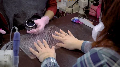Manicure master applying gel base on the nails of the client in the beauty salon Stock Footage 103732570