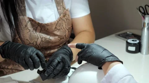 Manicure master in black gloves and a protective mask does a manicure Stock Footage 156282924