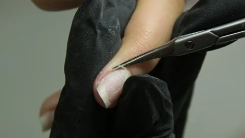 A manicure master in black gloves cuts off the cuticle with scissors Stock Footage 205524697