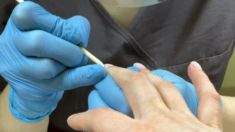 The manicure master cleanse the cuticle on the nails with a wooden stick Stock Footage 221192657