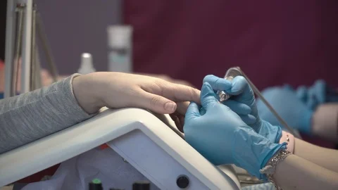 Manicure master cleanses the remnants of the old manicure from the nail Stock Footage 87466903