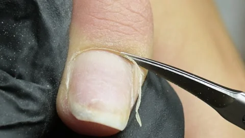The manicure master cuts off the cuticles macro. the master in the beauty sa Stock Footage 221361642