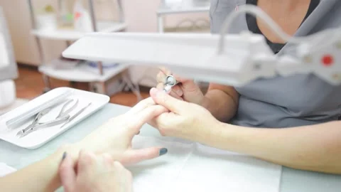 The manicure master cuts off the gel Polish on the client's hands Stock Footage 132184579