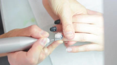 The manicure master cuts off the gel Polish on the client's hands Stock Footage 132184640