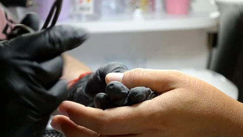 Manicure master in gloves cuts cuticle from client finger with thin scissors Stock Footage 122645530