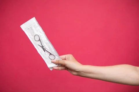 Manicure master holding scissors in sterilization envelopes. Stock Photos