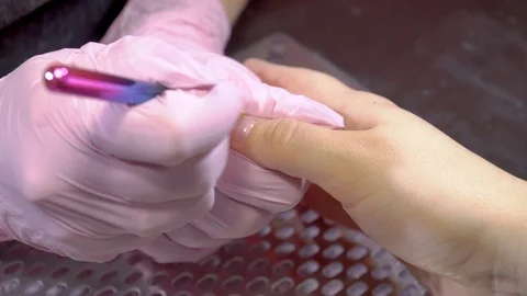 Manicure master makes the shape nail by applying gel Stock Footage 103733053