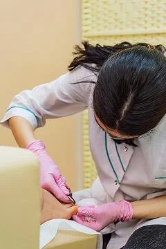 Manicure master in the process of working on the client's feet Stock Photos