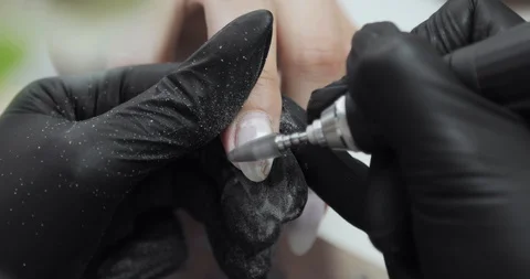 Manicure master removing old shellac from woman's nail using electric machine. 스톡 동영상 126823364