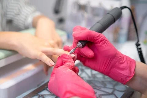 Manicure master uses a drill machine for a manicure at a beauty salon, Stock Photos