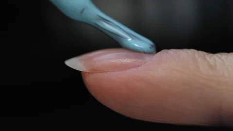 Manicure nail paint. Master applies gel polish on nails  in manicure salon. Stock Footage 124090906