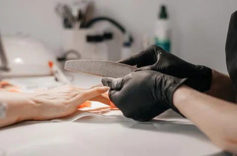 Manicure process. The master does a manicure. Two women in medical masks. Man Stock Photos