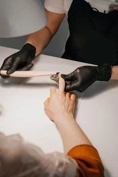 Manicure process. The master does a manicure. Two women in medical masks. Man Stock Photos