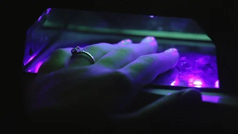 Manicure process. Woman's hand in UV lamp for gel polish. Close up Video stock 98713350