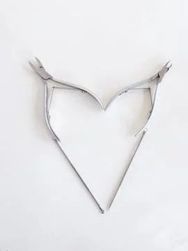 Manicure tools are folded in the shape of a heart on a white background, top Stock Photos
