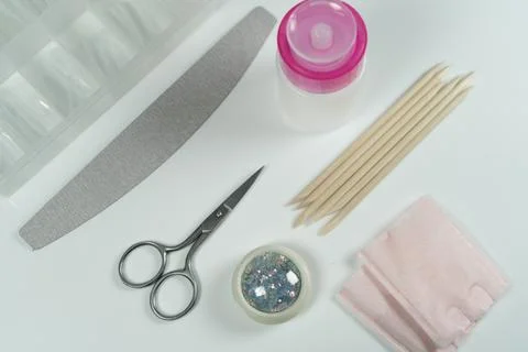 Manicure tools including scissors, a nail file, and glitter. Stock Photos