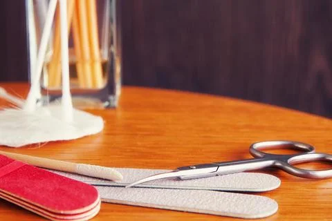 Manicure tools set, scissors, nail file, cotton swab on the wooden display Stock Photos
