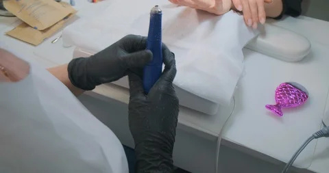 Manicurist adjusts machine and client waits for procedure Stock Footage 127952710