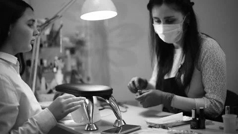 Manicurist with client choose design of nails watching telephone  and paints . Stock Footage 236012535