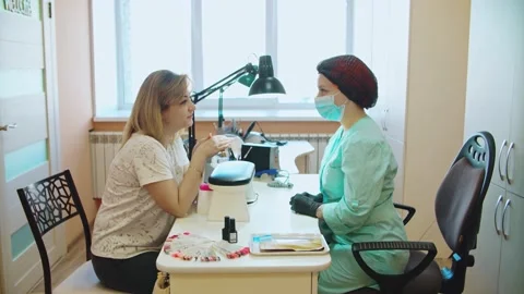 The manicurist communicates with the client and listens to Stock Footage 152986707