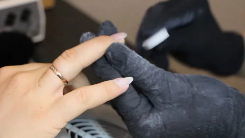 Manicurist creates the correct form of nails with a nail file. Stock Footage 111511999